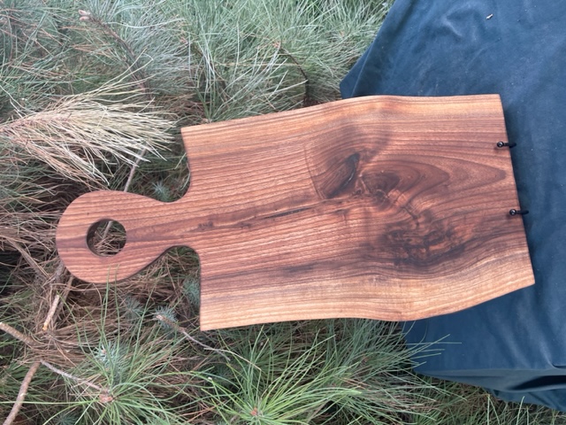 A black walnut large charcuterie board with handle.