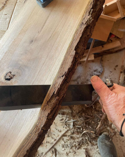 Man's hand sawing wood.