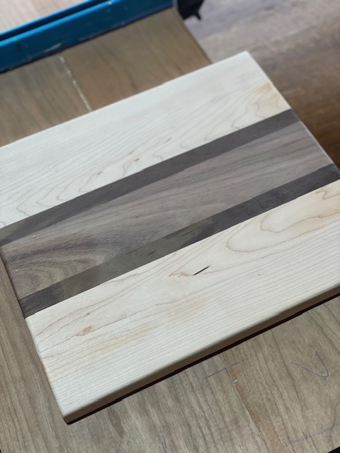 Natural wood with large brown stripe in the middle cheese and/or personal board.